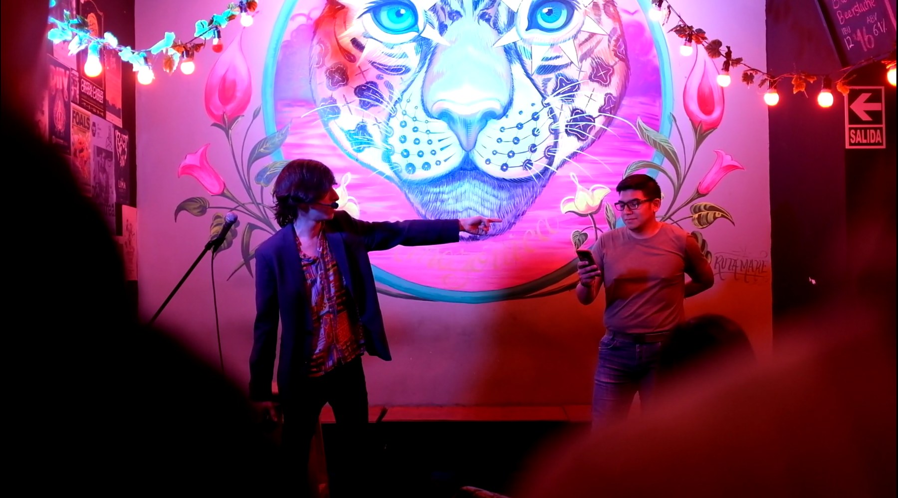 A participant experiences a magic performance beneath a colourful illustrated face.