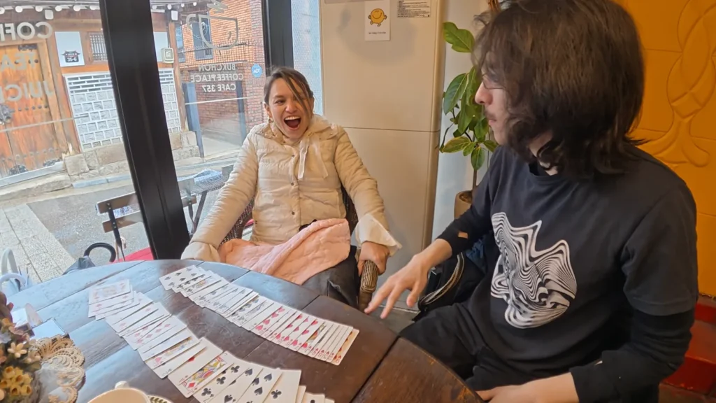 A spectator reacting to Sebastián’s card magic at a café table.
