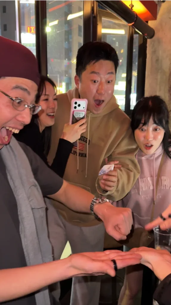 A group reacting with surprise during a close-up magic moment.